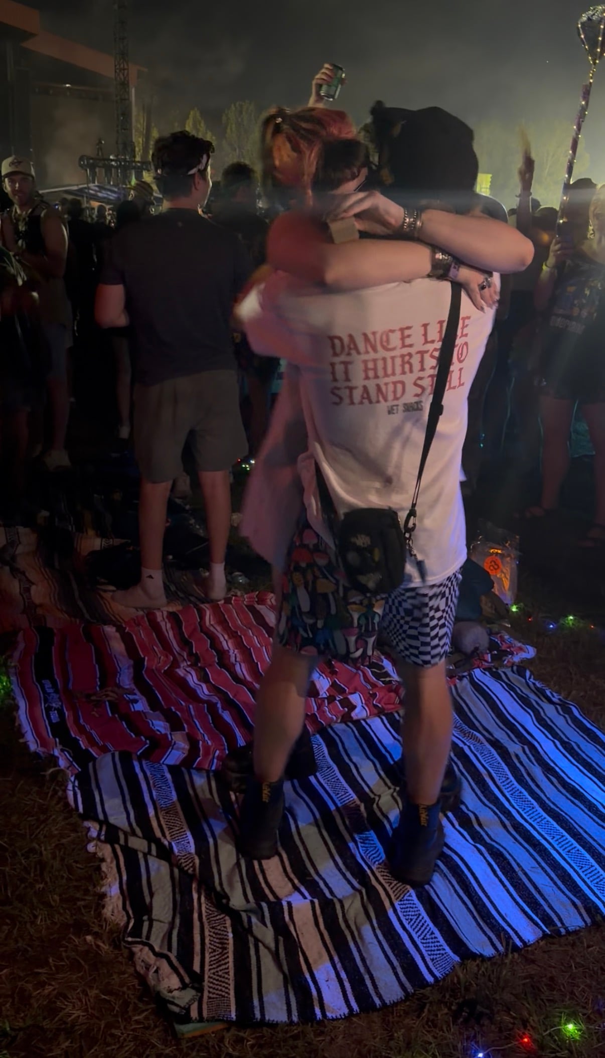 Embrace after the proposal — "dance like it hurts to stand still" on the shirt.